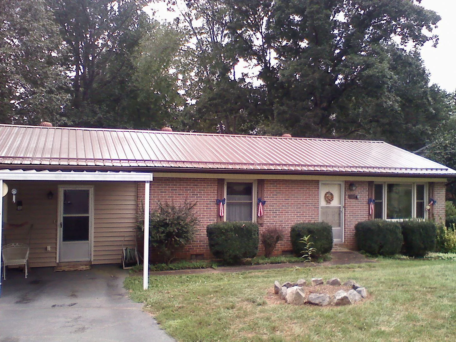 Bronze metal roof and carport on a brick ranch home — Roof Repair work by our crew in Roselle
